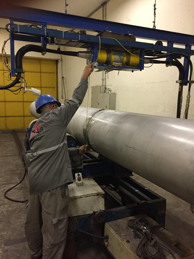 Técnico da CB Inspeções posiciona um tubo de aço sob o aparelho de raios X no bunker de radiografia