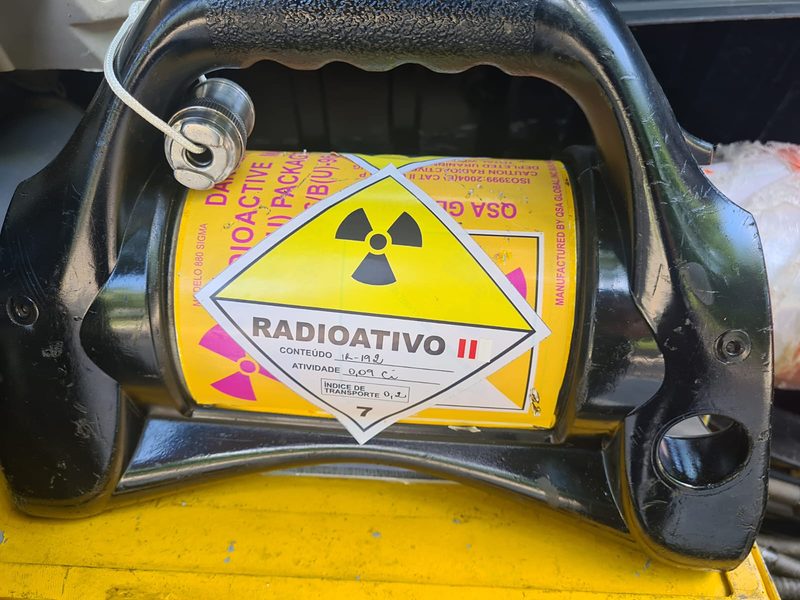 Irradiador gama (projetor de fonte) com rótulo de material radioativo classe II, equipamento usado na gamagrafia industrial